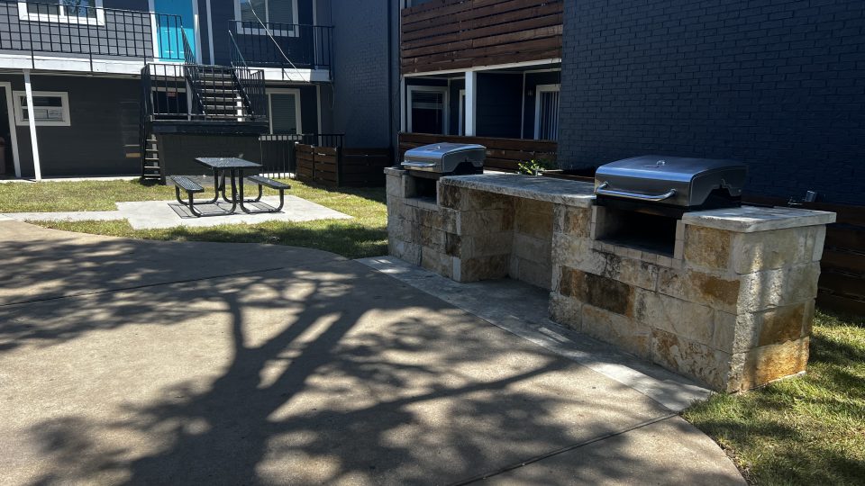 a patio with a grill and a barbecue at The Calypso Court Apartments